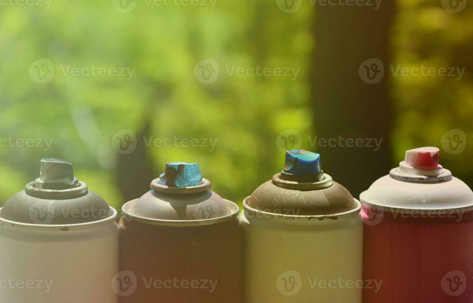 A few used aerosol paint sprayers lie on the windowsill in the workshop of a graffiti artist. The concept of street art and illegal drawing on the walls. Youth hobby photo