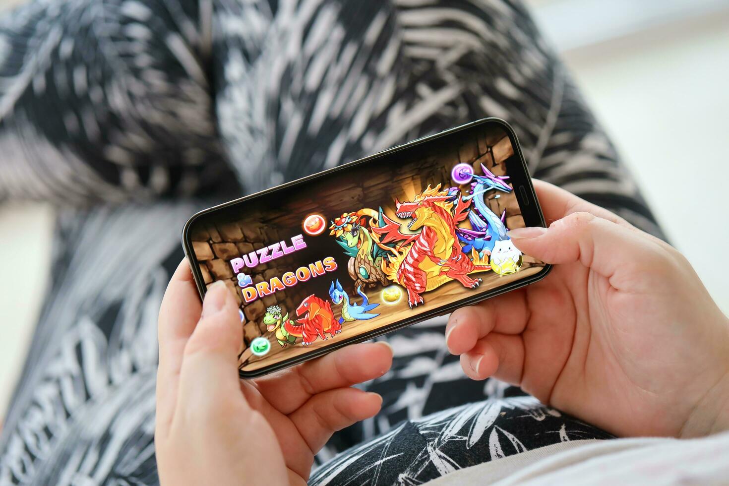 Puzzle and dragons mobile iOS game on iPhone 15 smartphone screen in female hands during mobile gameplay photo