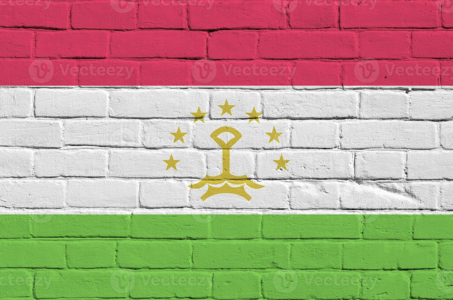 Tajikistan flag depicted in paint colors on old brick wall. Textured banner on big brick wall masonry background photo