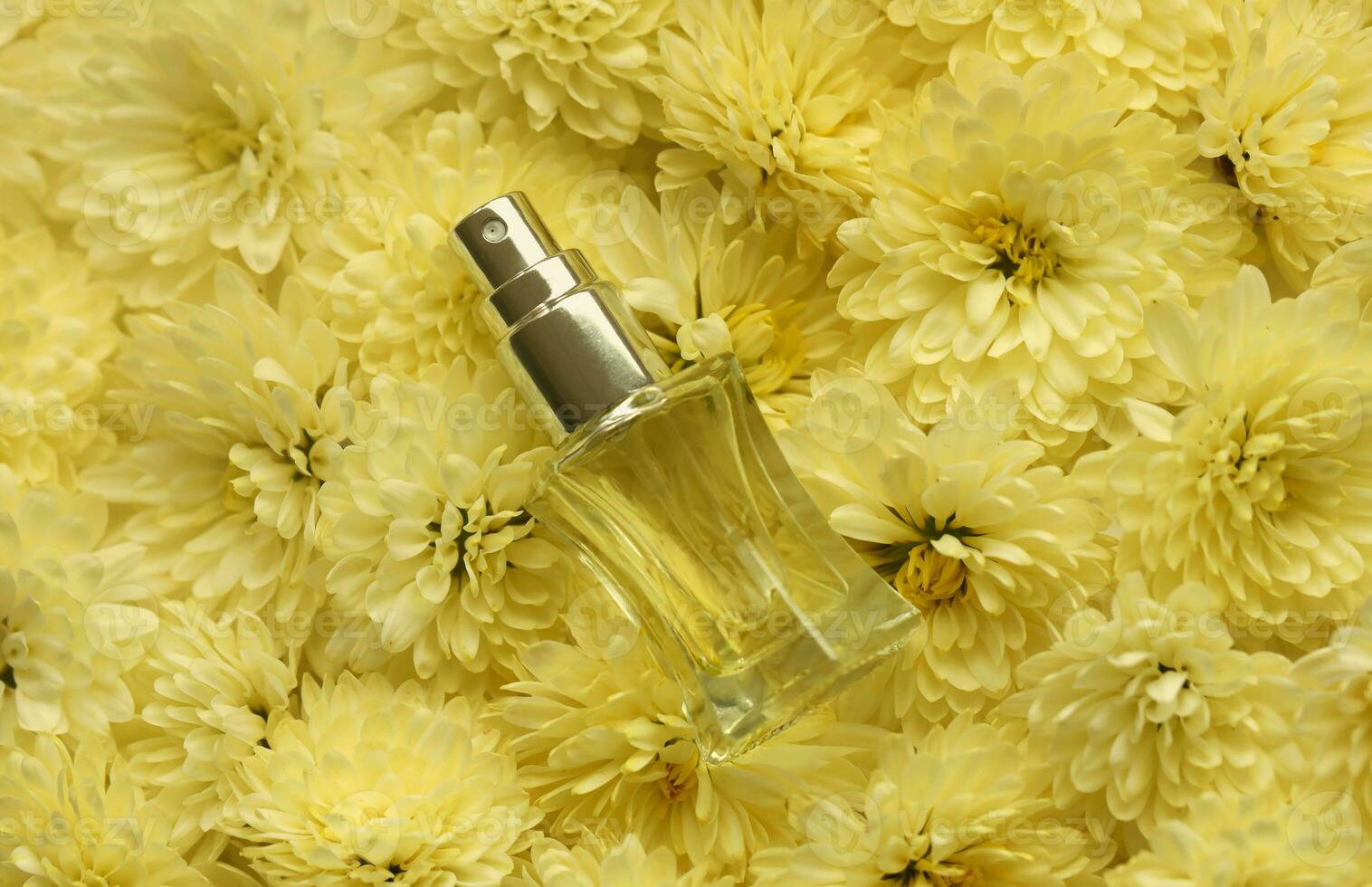 Women fragrance perfume bottle with flowers background close up. Unnamed blank sprayer bottle of perfume photo
