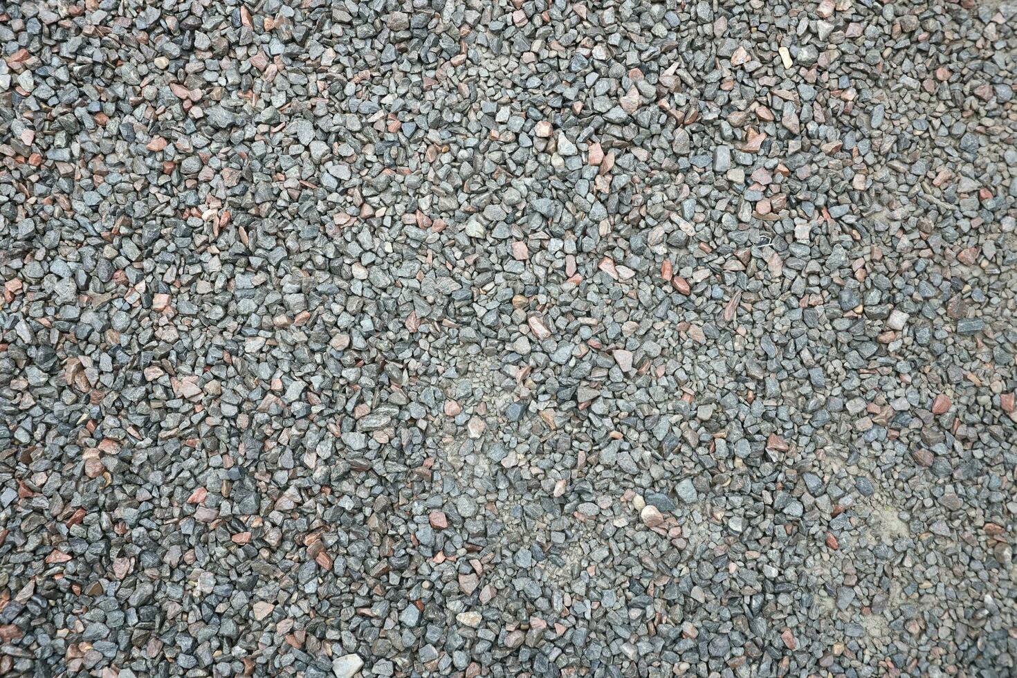 Close up of muddy puddle with small stones on wet surface. Background texture with top view photo
