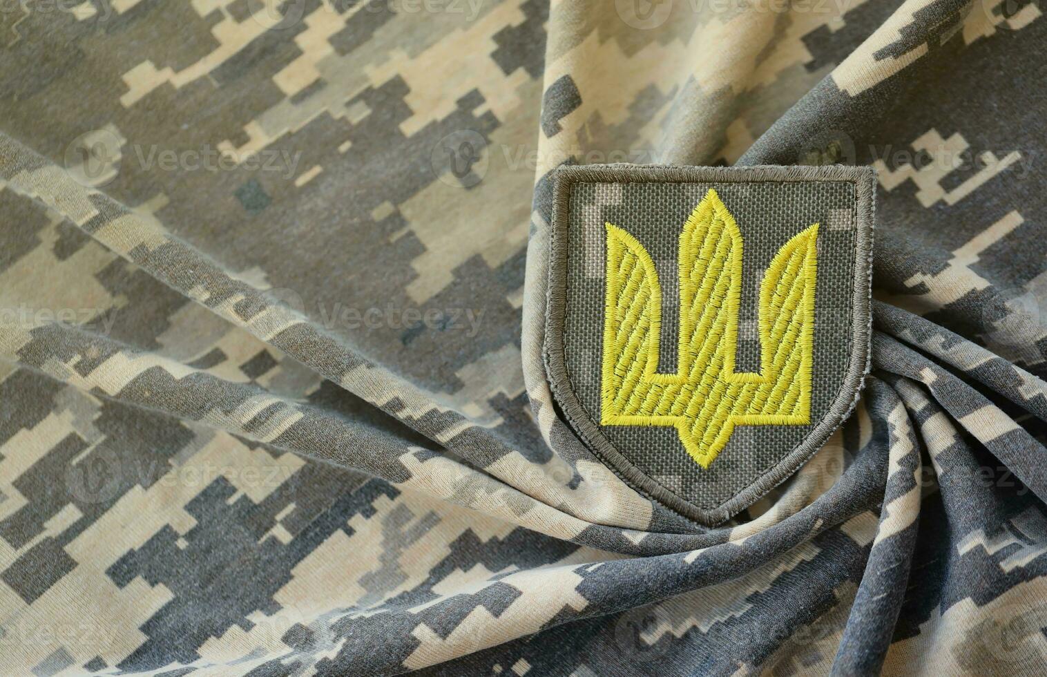 Symbol of Ukrainian army on the camouflage uniform of a Ukrainian soldier. The concept of war in Ukraine, patriotism and protecting your country from occupiers photo