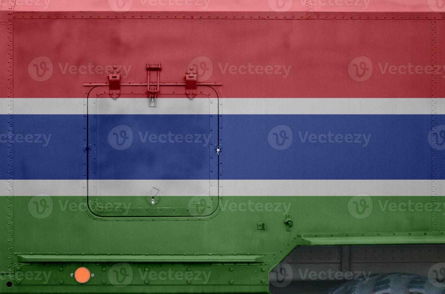 Gambia flag depicted on side part of military armored truck closeup. Army forces conceptual background photo