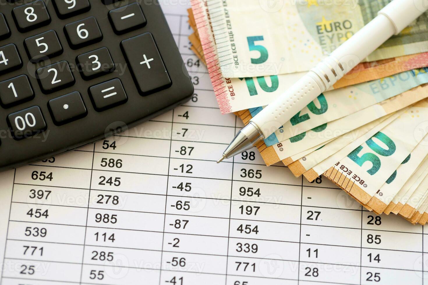 Business concept with many euro money bills, calculator and pen photo