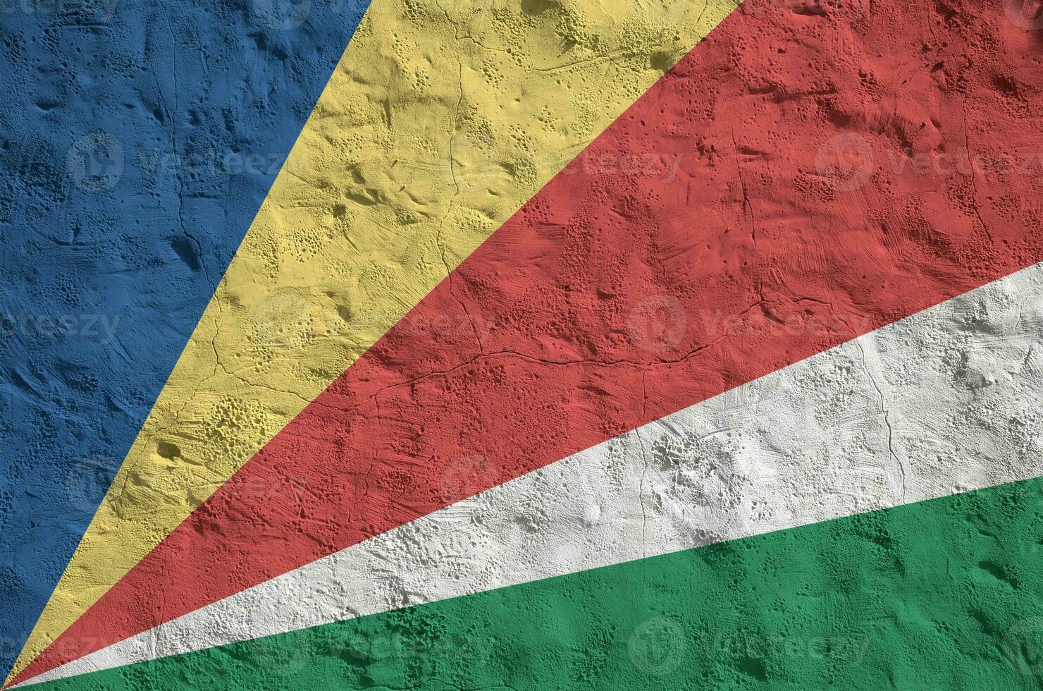 Seychelles flag depicted in bright paint colors on old relief plastering wall. Textured banner on rough background photo
