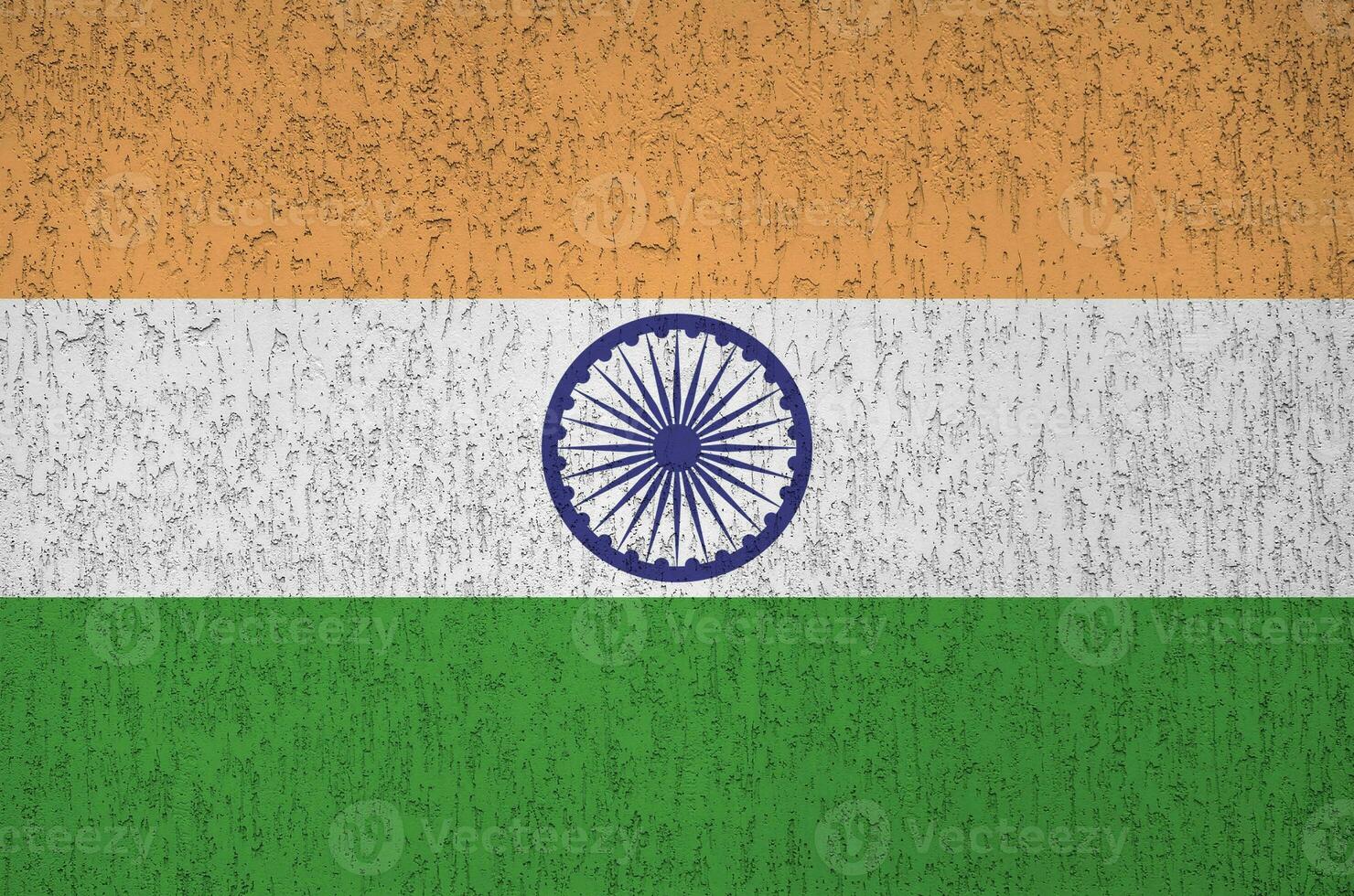 India flag depicted in bright paint colors on old relief plastering wall. Textured banner on rough background photo