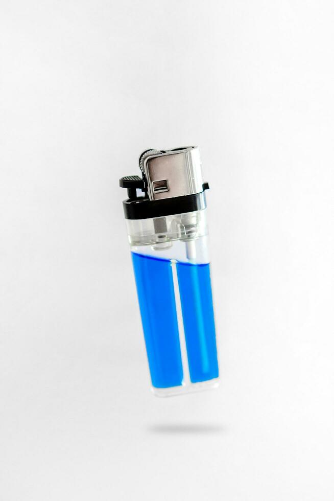 Blue plastic lighter floating on white background photo