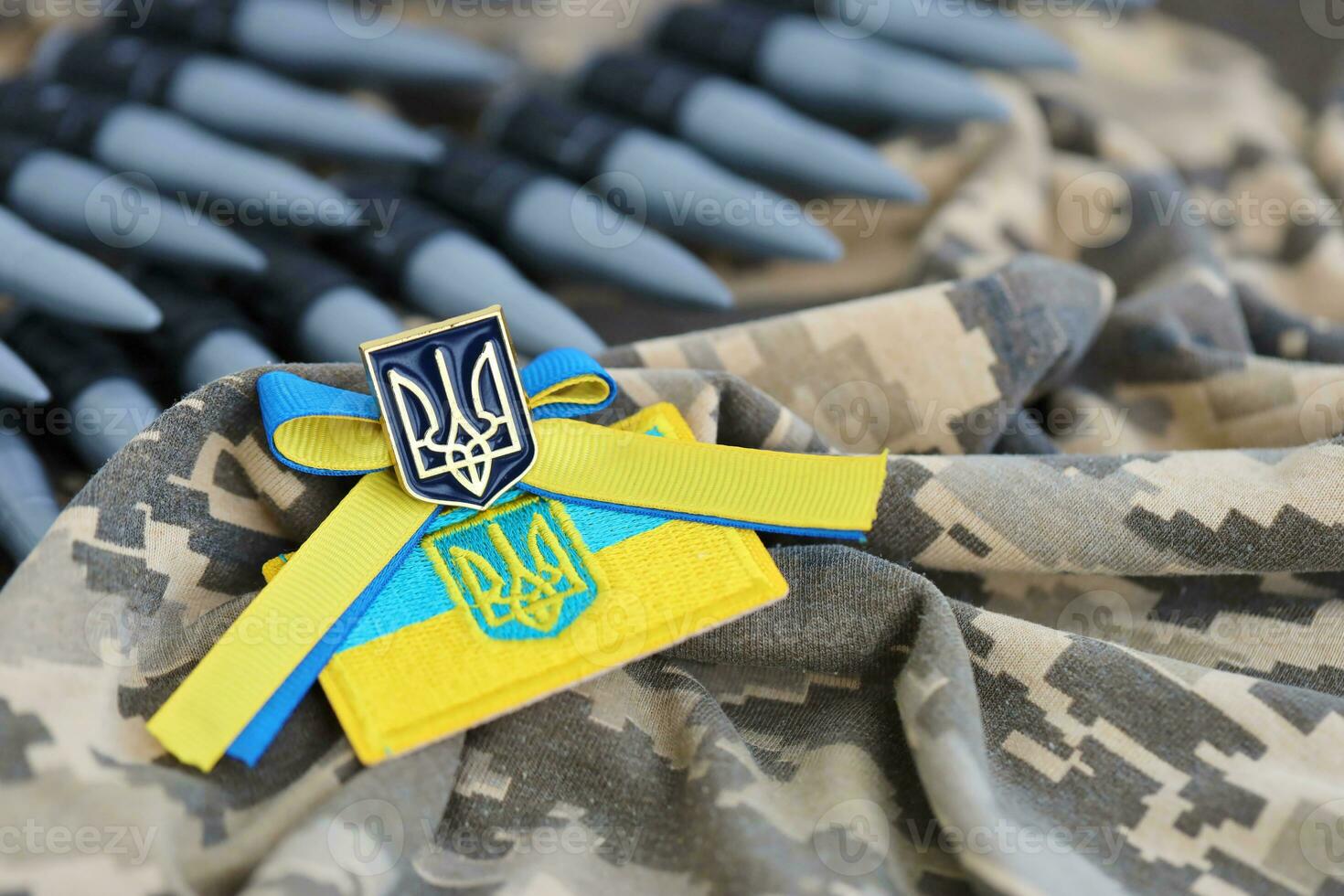 Ukrainian symbol and a machine gun belt on the camouflage uniform of a Ukrainian soldier. The Concept of war in Ukraine, patriotism and protecting your country from occupiers photo