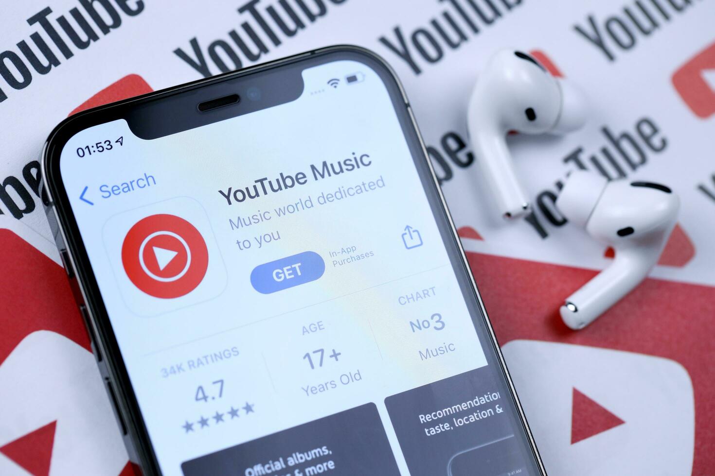 KHARKOV, UKRAINE - MARCH 5, 2021 Youtube music icon and application from App store on iPhone 12 pro display screen with airpods pro on white table photo