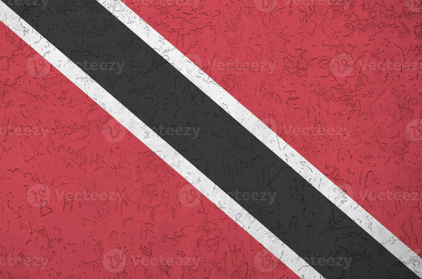 Trinidad and Tobago flag depicted in bright paint colors on old relief plastering wall. Textured banner on rough background photo