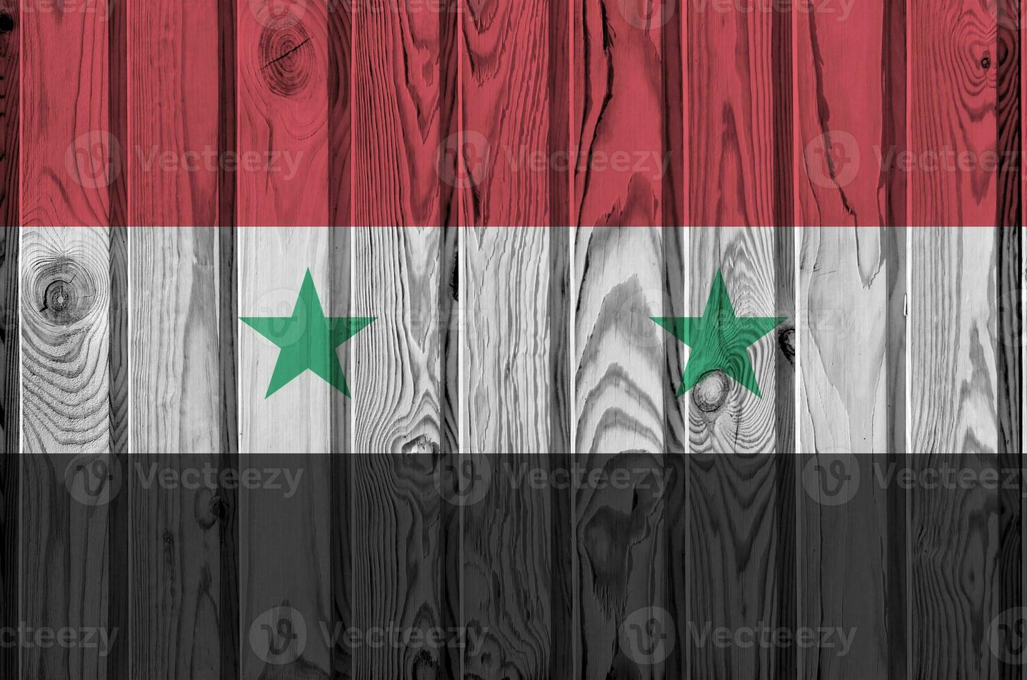 Syria flag depicted in bright paint colors on old wooden wall. Textured banner on rough background photo