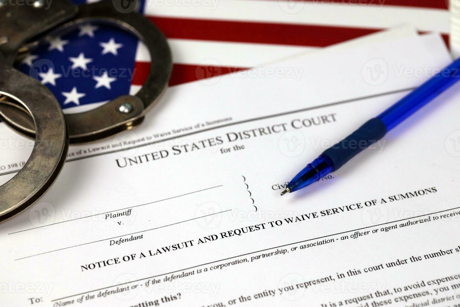 District court Notice of the lawsuit and request to waive service of a summons. Papers with handcuffs and blue pen on United States flag photo