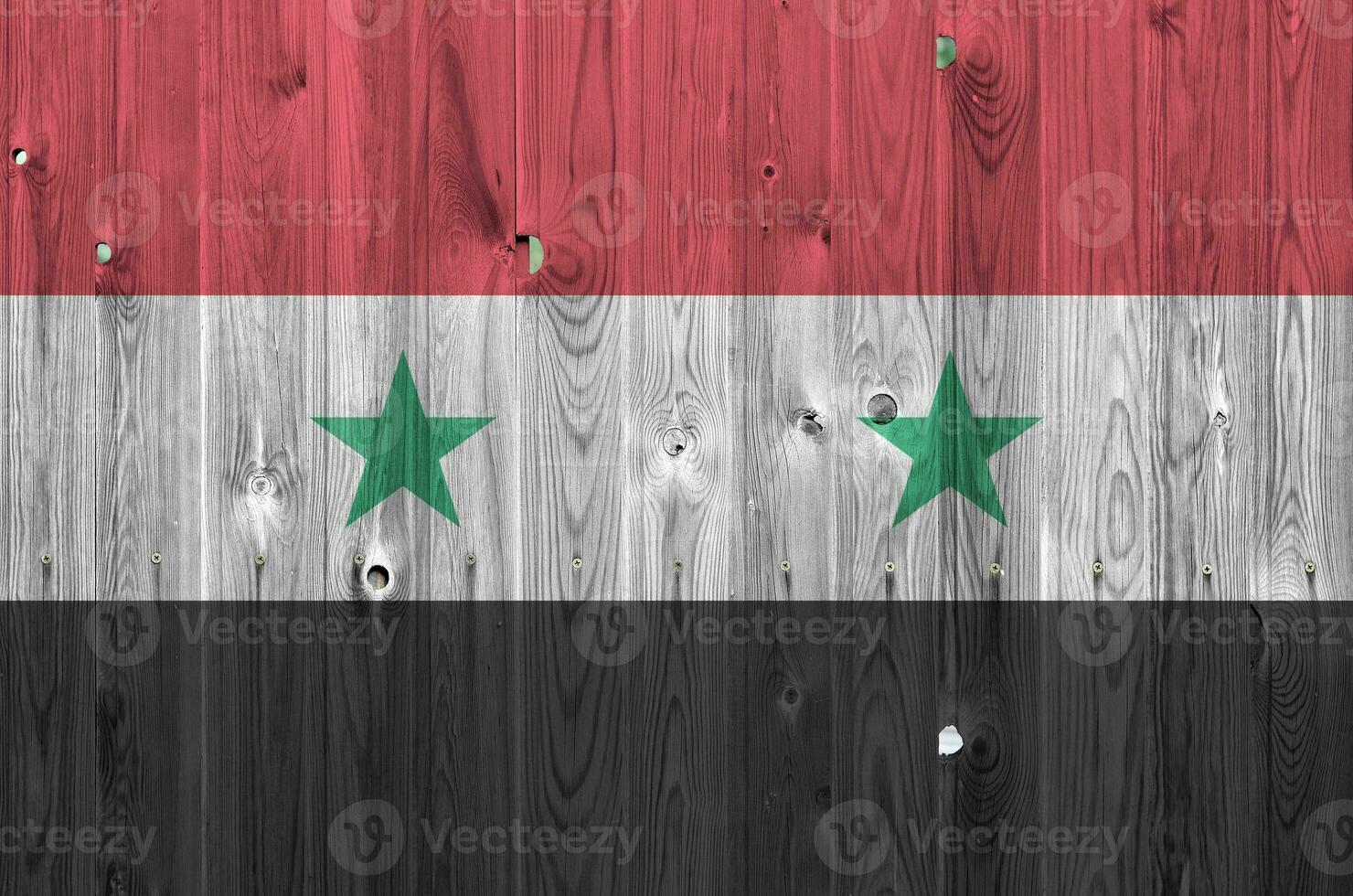 Syria flag depicted in bright paint colors on old wooden wall. Textured banner on rough background photo