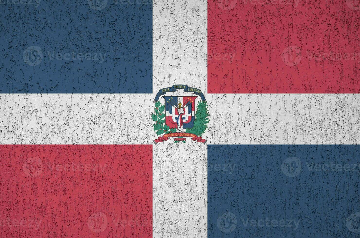 Dominican Republic flag depicted in bright paint colors on old relief plastering wall. Textured banner on rough background photo