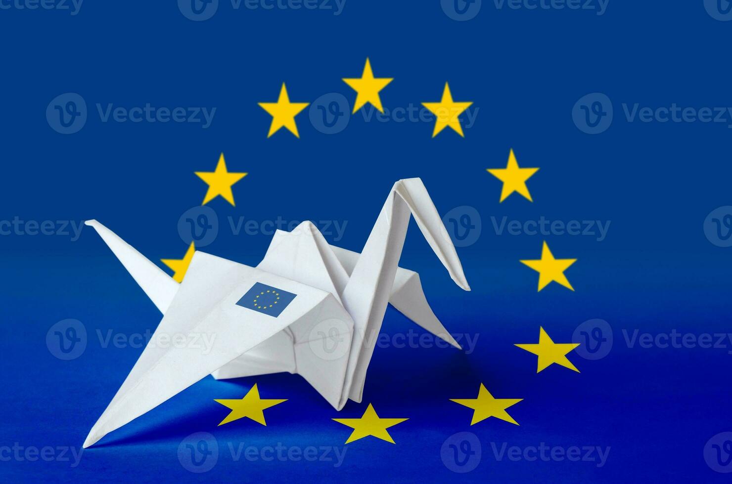 European union flag depicted on paper origami crane wing. Handmade arts concept photo