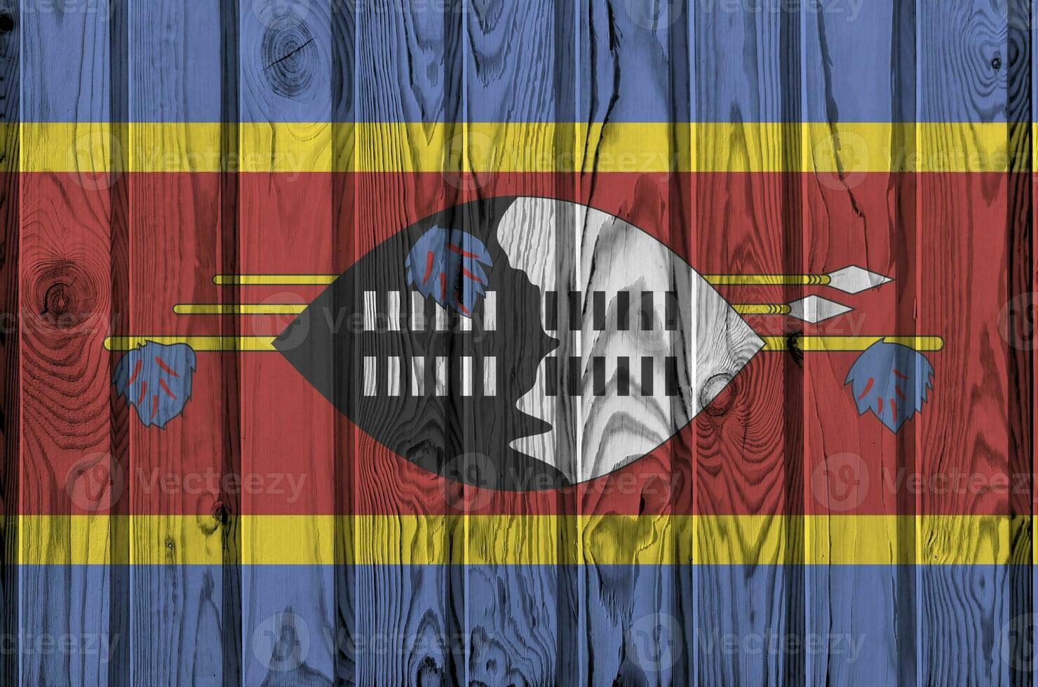 Swaziland flag depicted in bright paint colors on old wooden wall. Textured banner on rough background photo