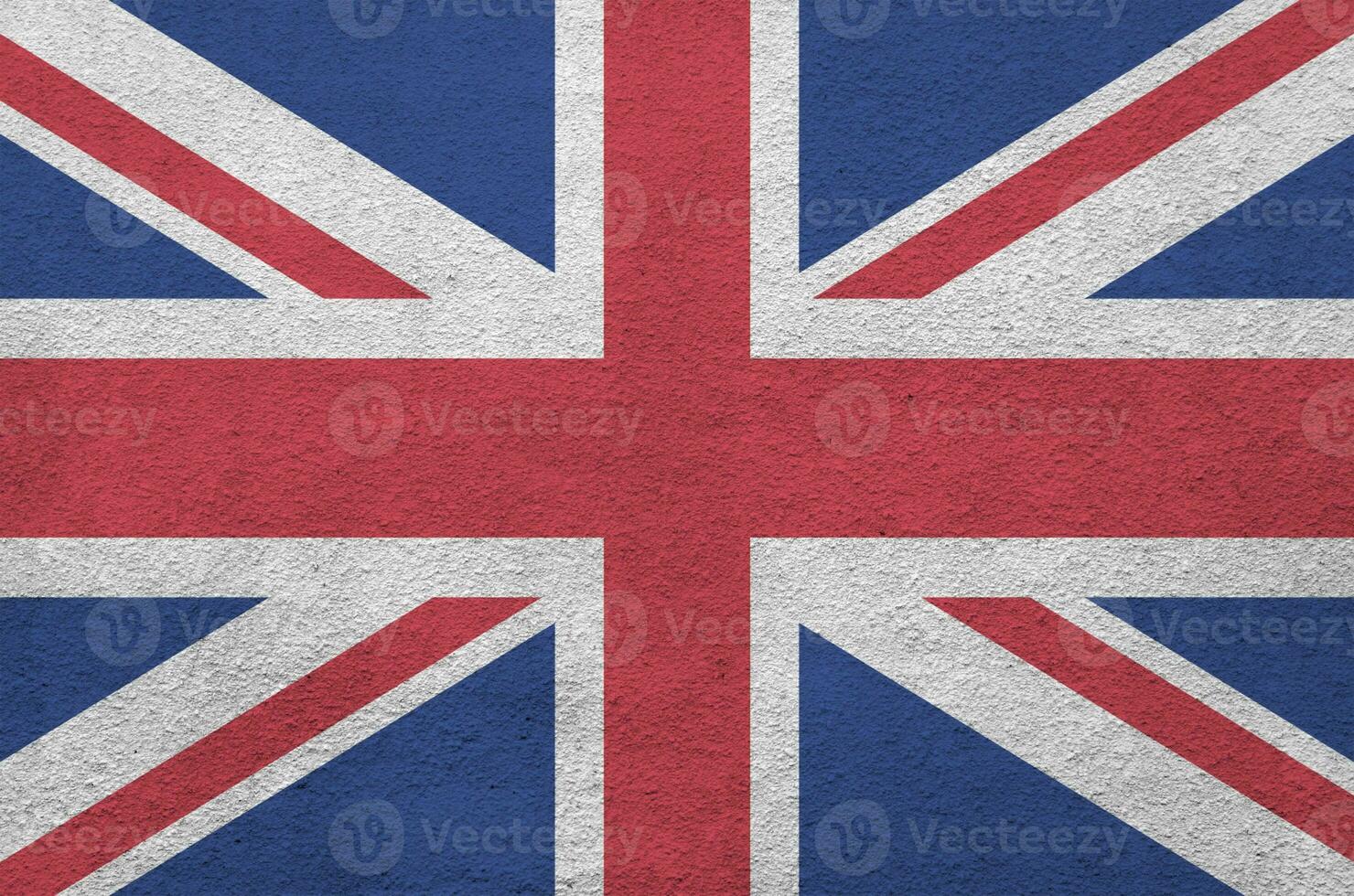 Great britain flag depicted in bright paint colors on old relief plastering wall. Textured banner on rough background photo