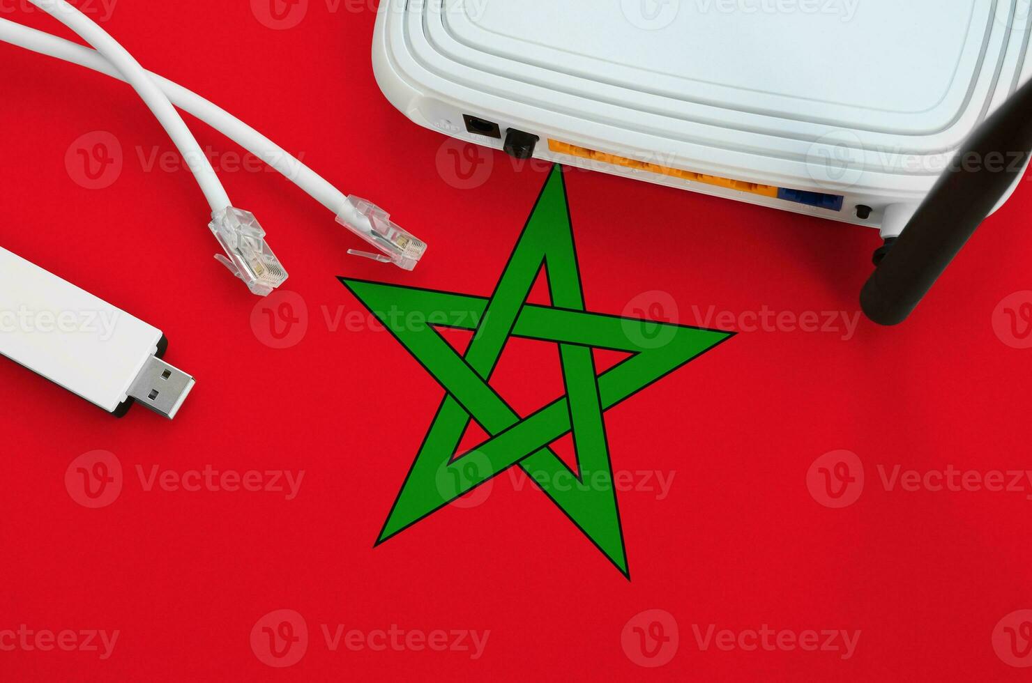 Morocco flag depicted on table with internet rj45 cable, wireless usb wifi adapter and router. Internet connection concept photo