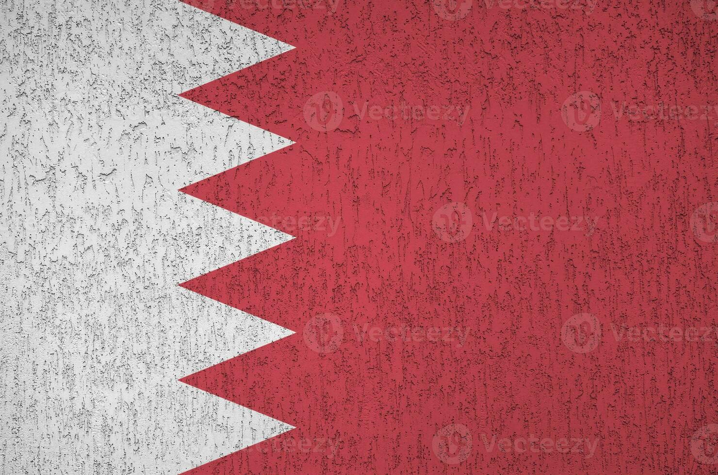 Bahrain flag depicted in bright paint colors on old relief plastering wall. Textured banner on rough background photo