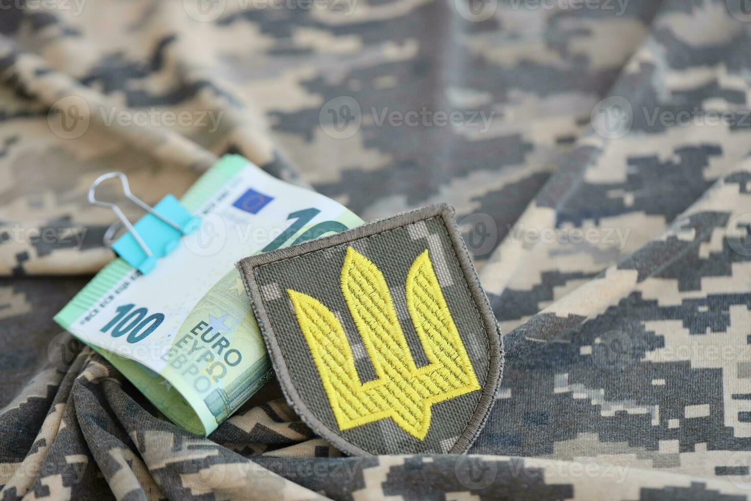 Ukrainian army symbol and bunch of euro bills on military uniform. Payments to soldiers of the Ukrainian army from European union, salaries to the military. War support photo