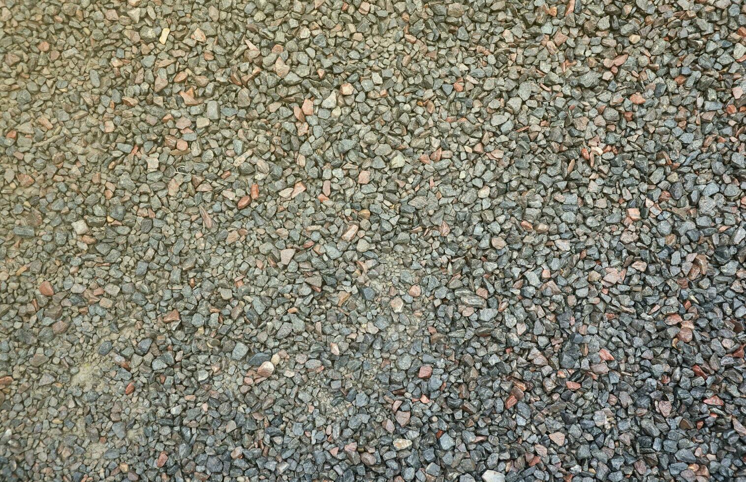 Close up of muddy puddle with small stones on wet surface. Background texture with top view photo
