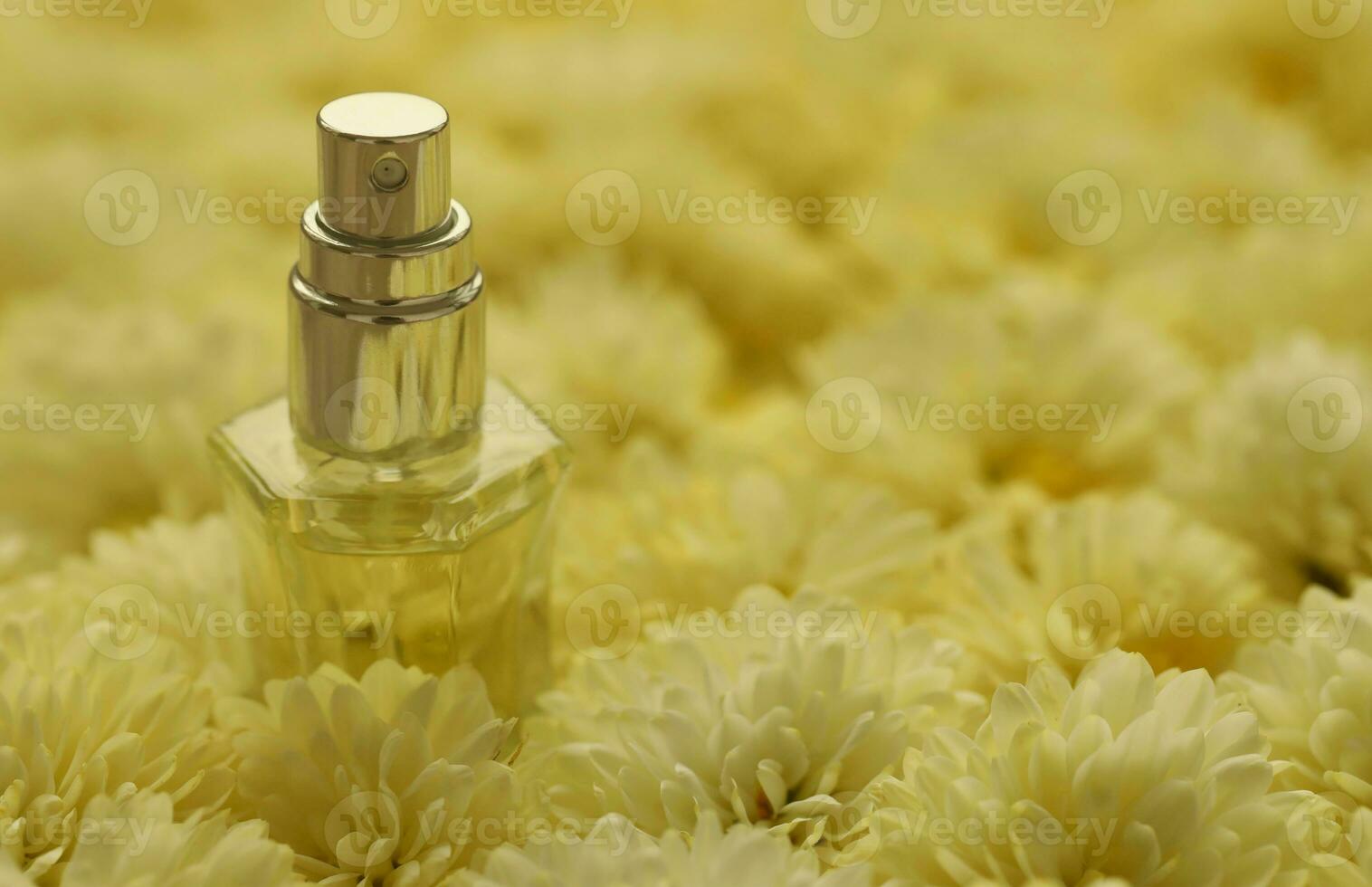Women fragrance perfume bottle with flowers background close up. Unnamed blank sprayer bottle of perfume photo