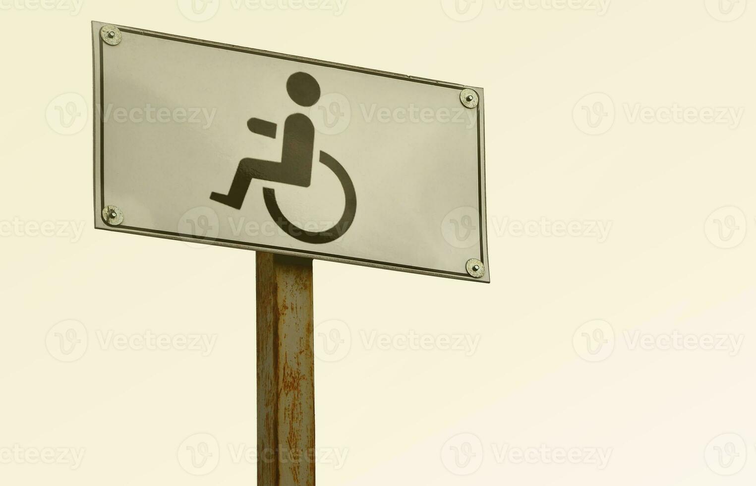 A road sign indicating the crossing of a road for disabled people. White road sign with a picture of a man sitting in a wheelchair photo