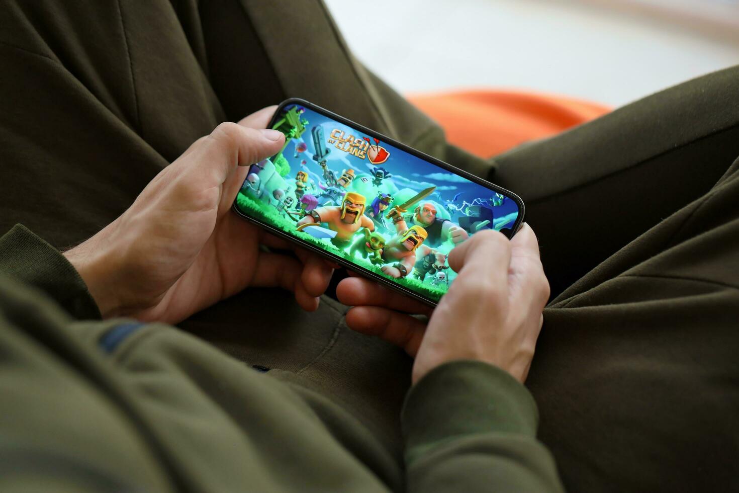 Clash of Clans mobile iOS game on iPhone 15 smartphone screen in male hands during mobile gameplay photo