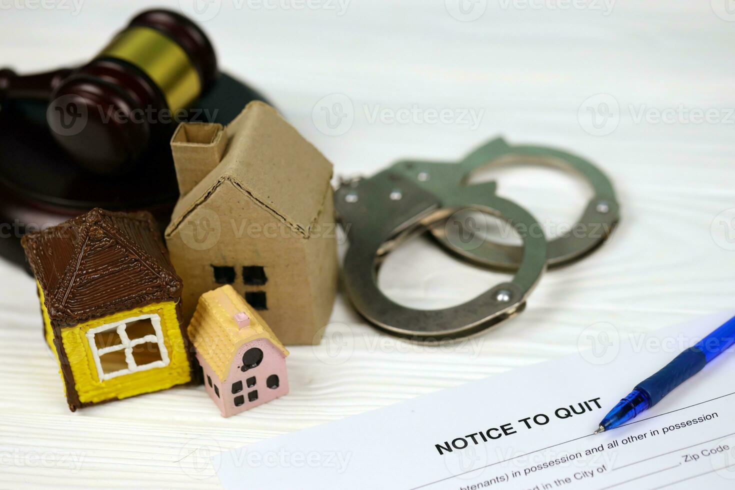 Notice to quit or eviction notice blank document paper ready to fill with judgement gavel, handcuffs and small toy houses on table photo