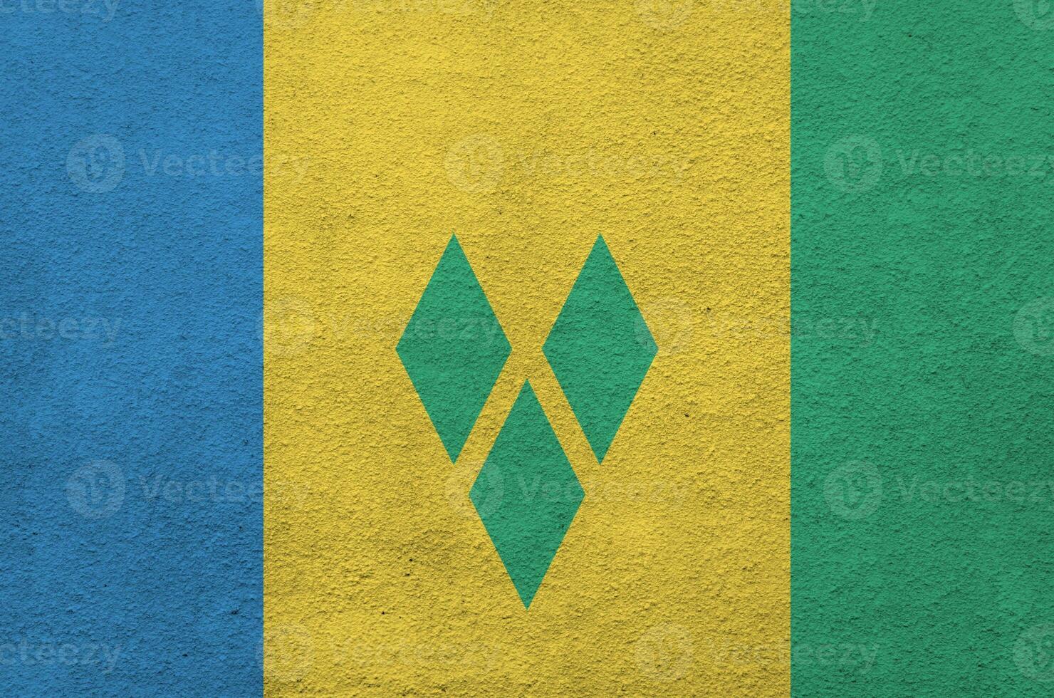 Saint Vincent and the Grenadines flag depicted in bright paint colors on old relief plastering wall. Textured banner on rough background photo
