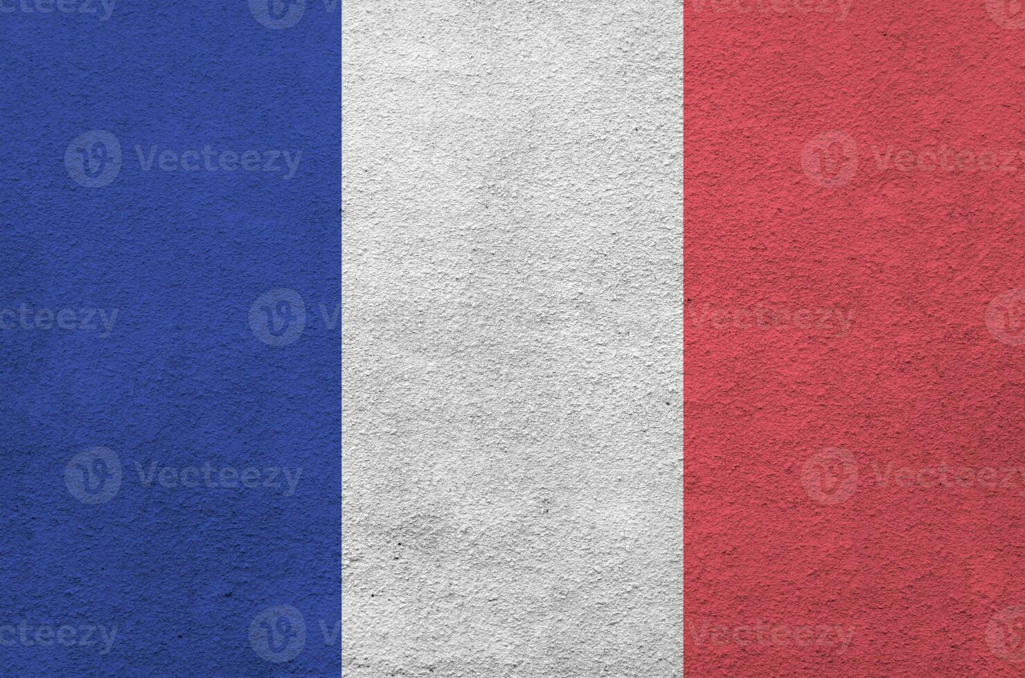 France flag depicted in bright paint colors on old relief plastering wall. Textured banner on rough background photo