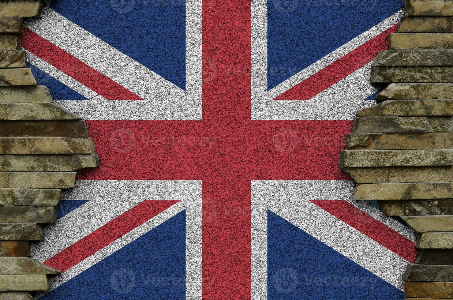 Great britain flag depicted in paint colors on old stone wall closeup. Textured banner on rock wall background photo