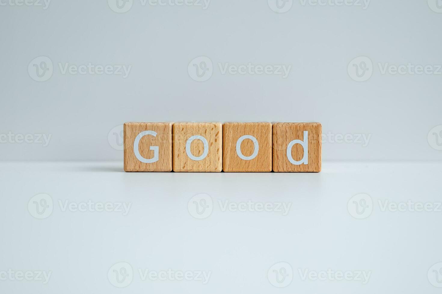 Wooden blocks form the text Good against a white background. photo