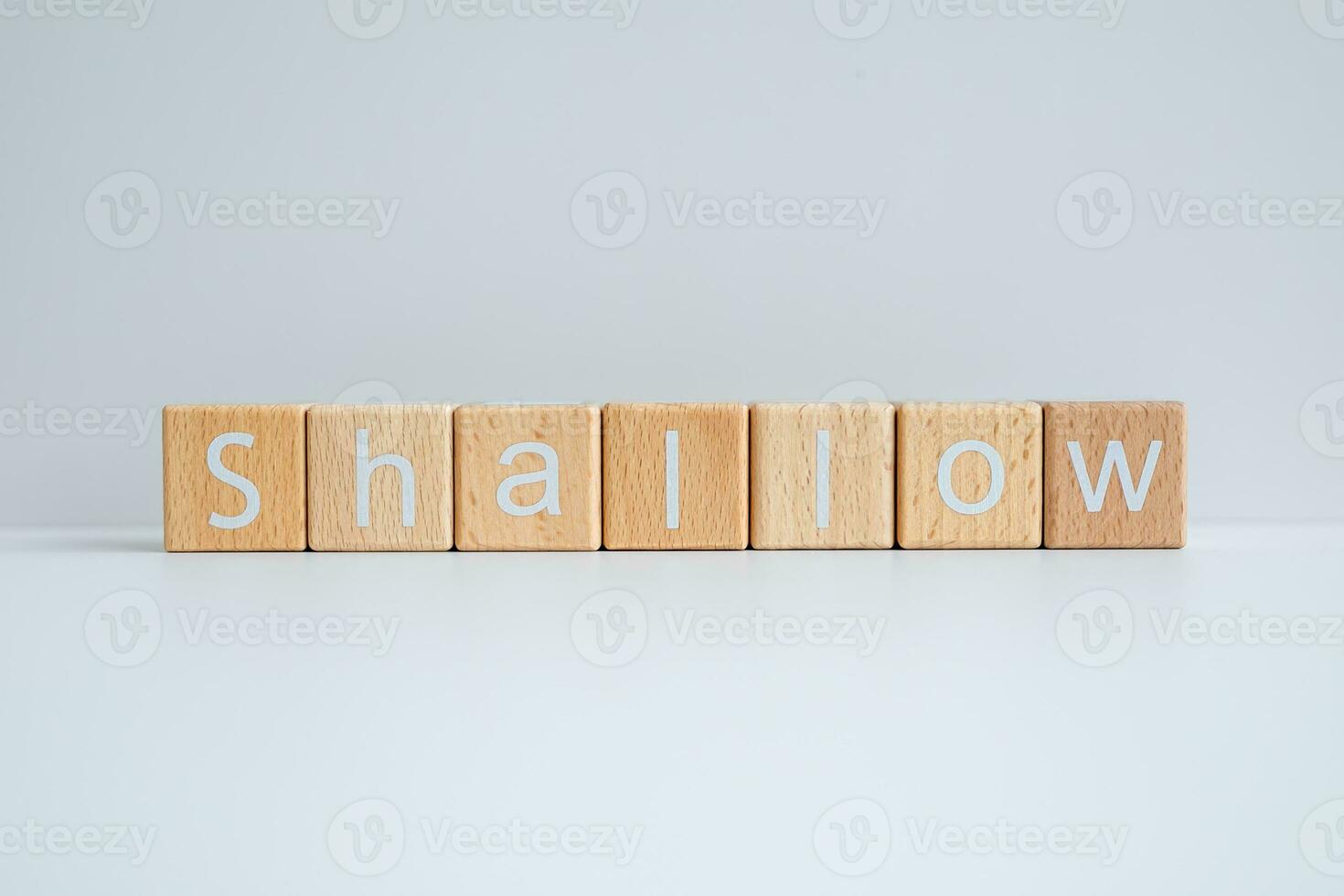 Wooden blocks form the text Shallow against a white background. photo