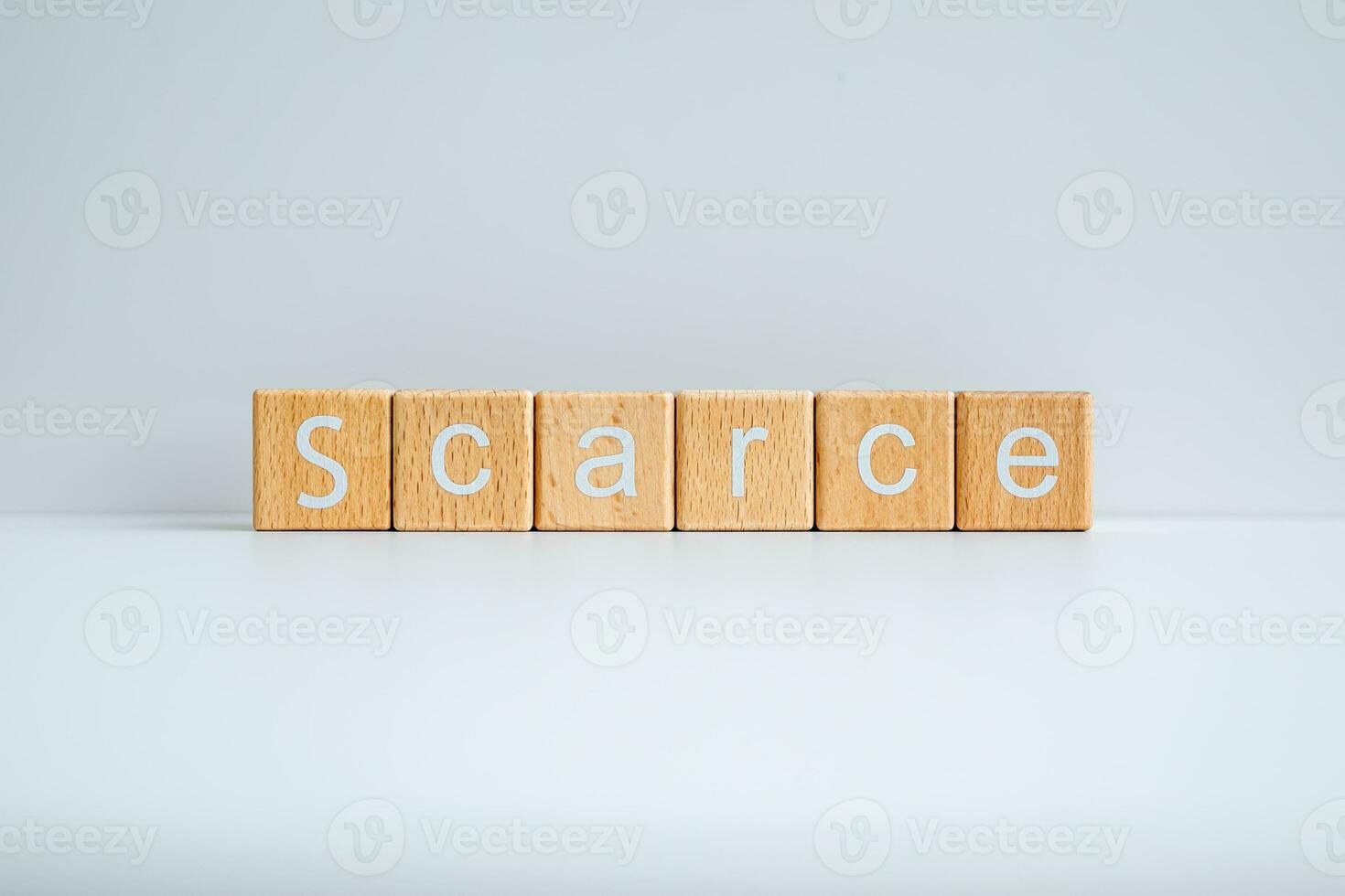 Wooden blocks form the text Scarce against a white background. photo