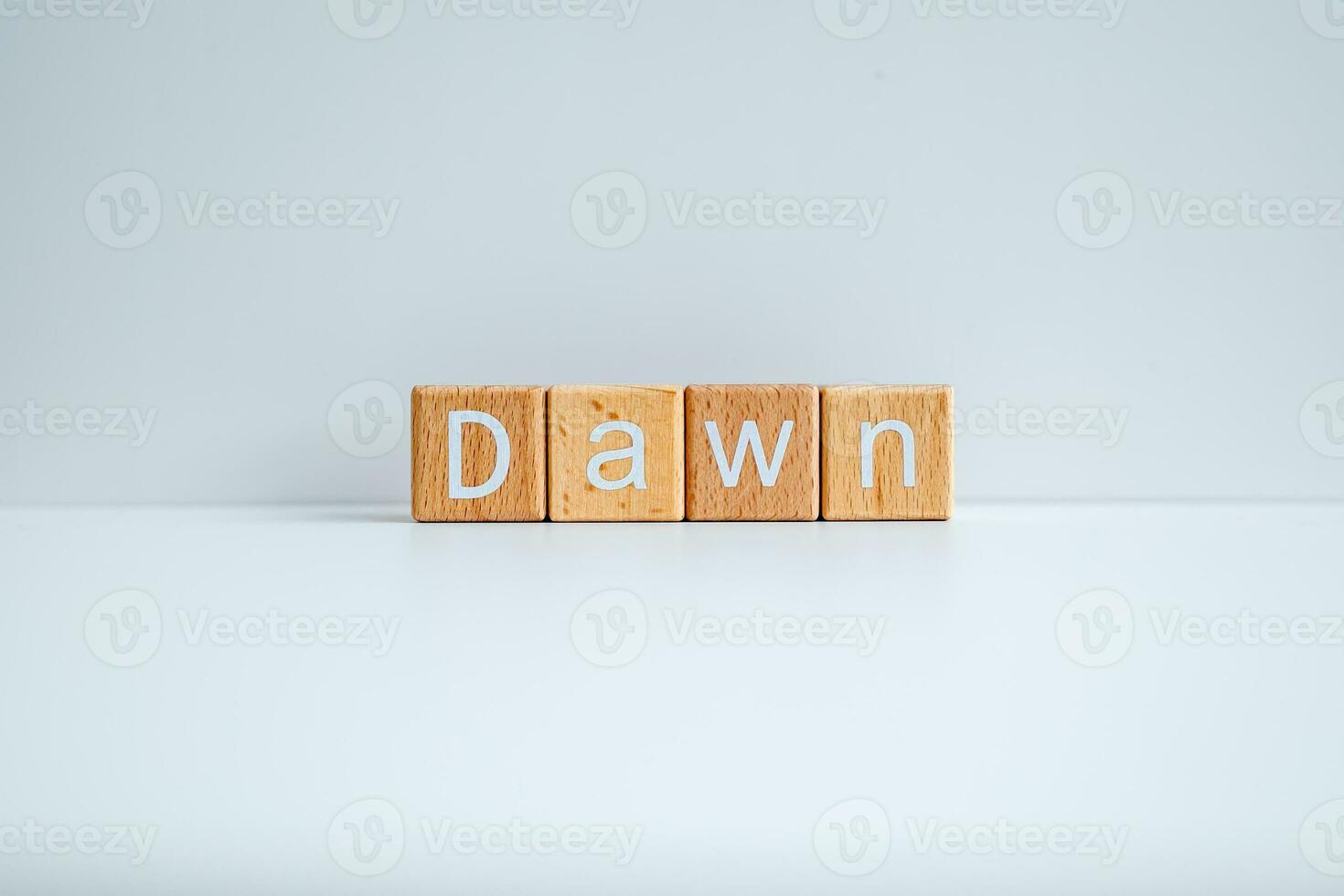 Wooden blocks form the text Dawn against a white background. photo