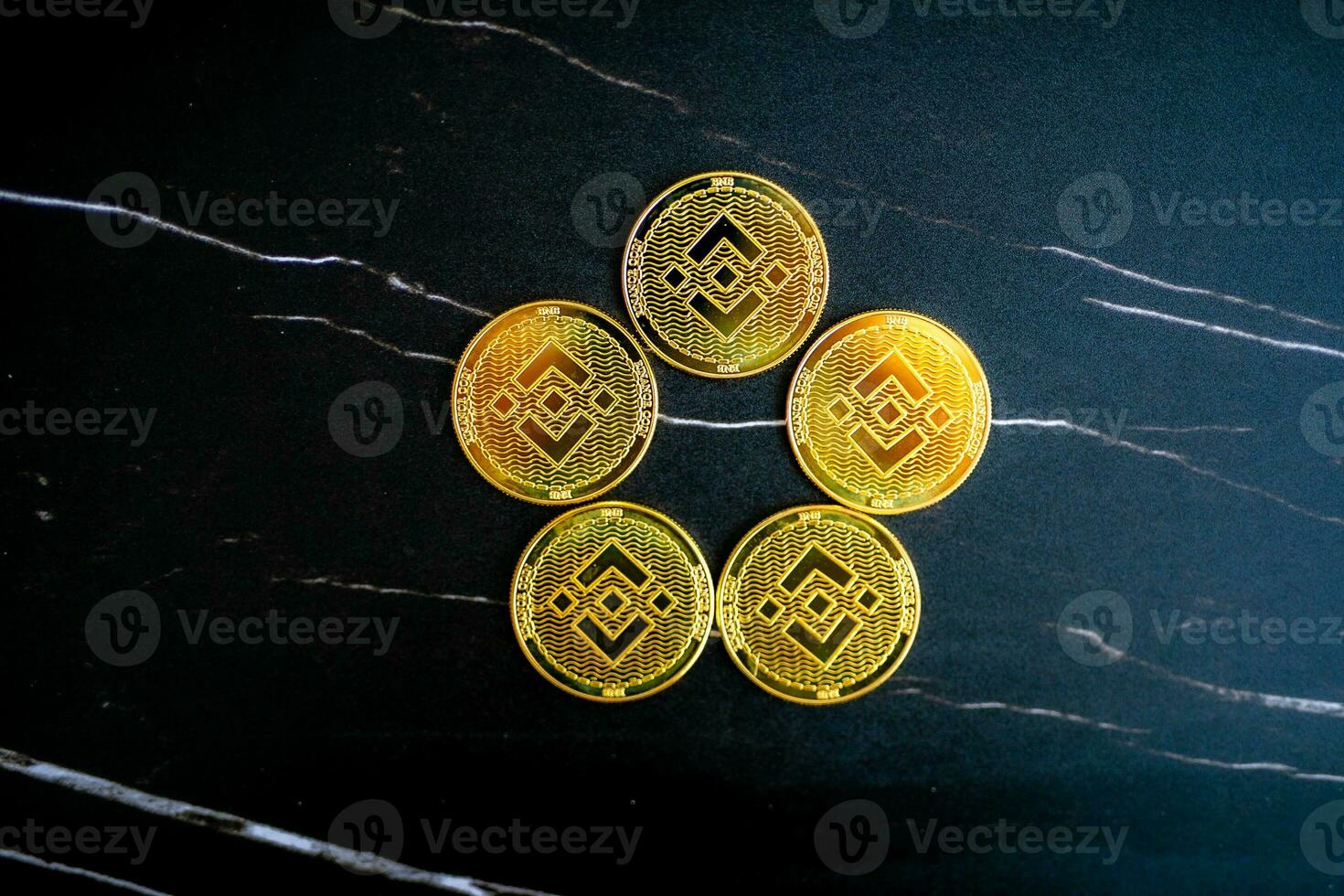 5 BNB coins BNB arranged in a circle on a black marble background. photo