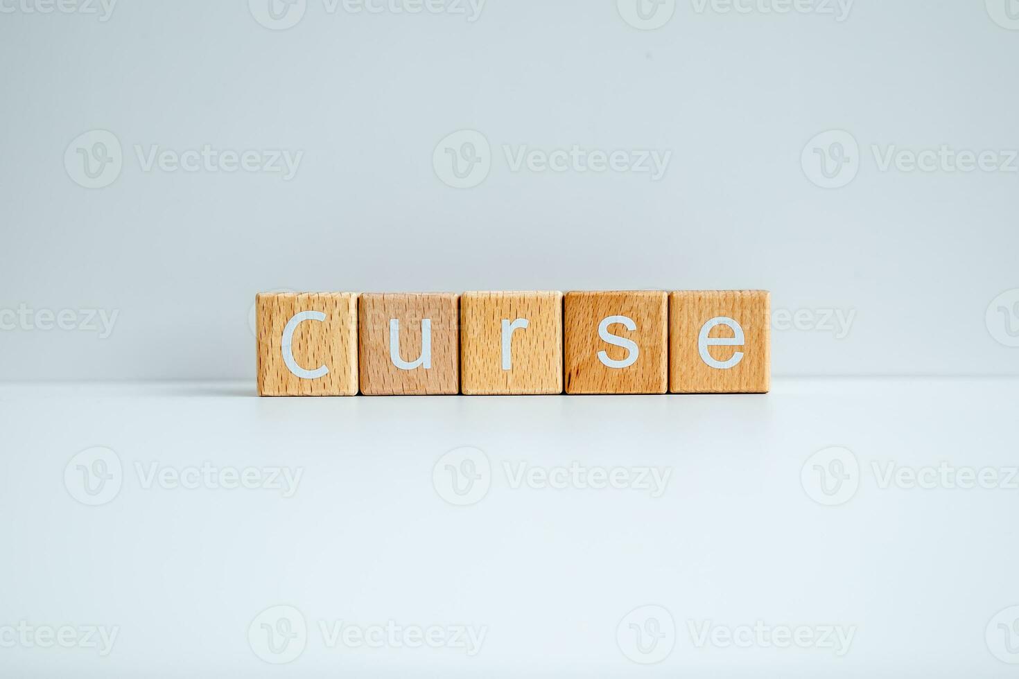 Wooden blocks form the text Curse against a white background. photo