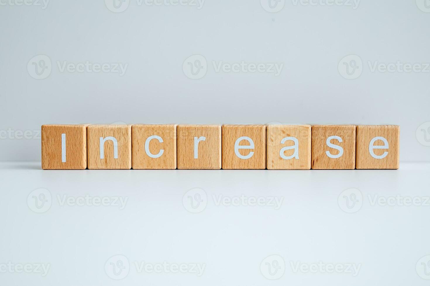 Wooden blocks form the text Increase against a white background. photo
