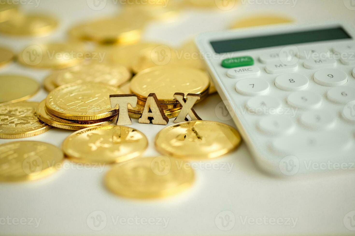 Flat wooden text written TAX, with many crypto coins with a calculator beside, Close up, Crypto concept. photo