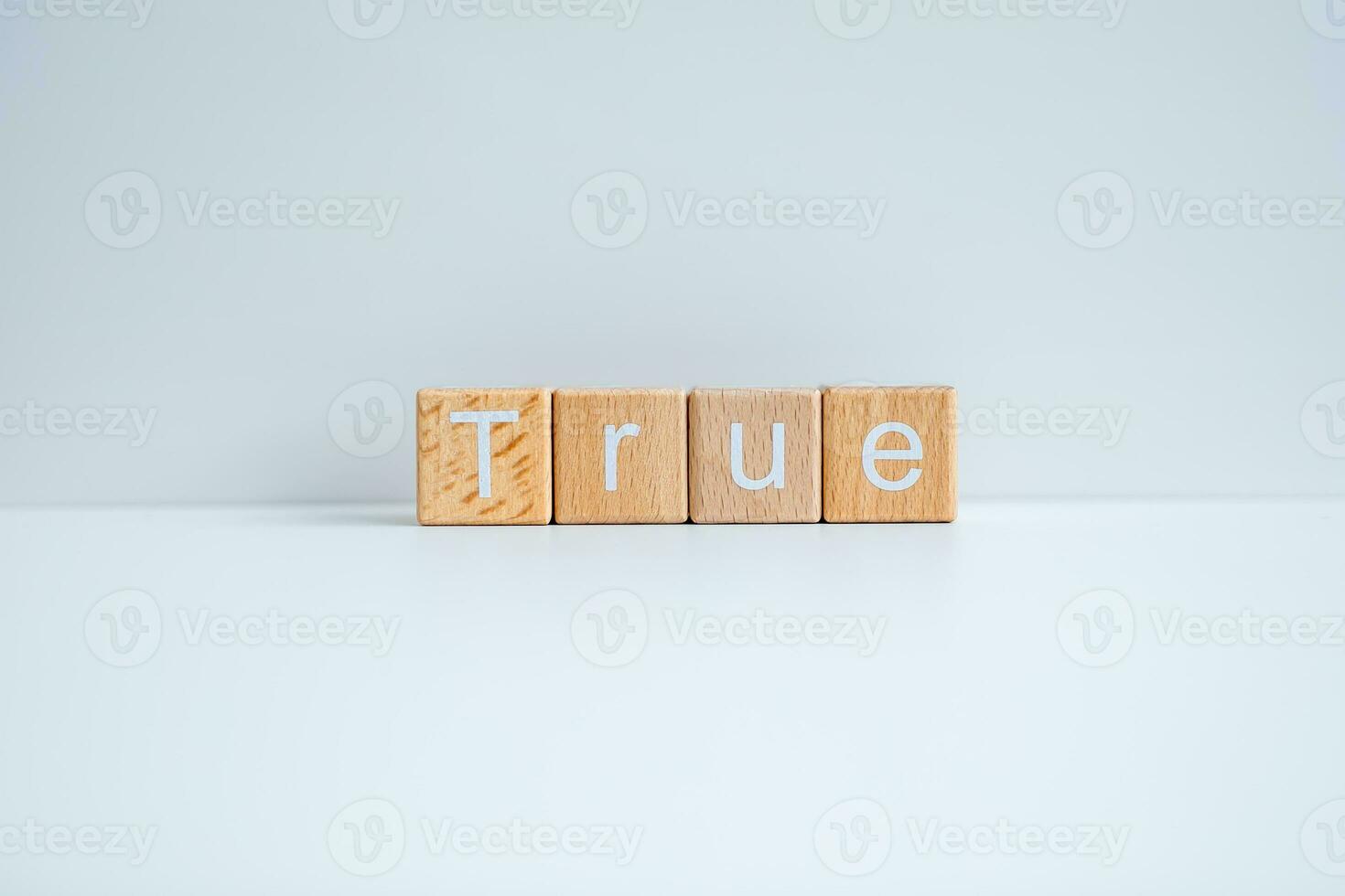 Wooden blocks form the text True against a white background. photo