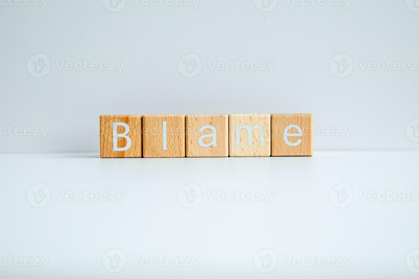 Wooden blocks form the text Blame against a white background. photo
