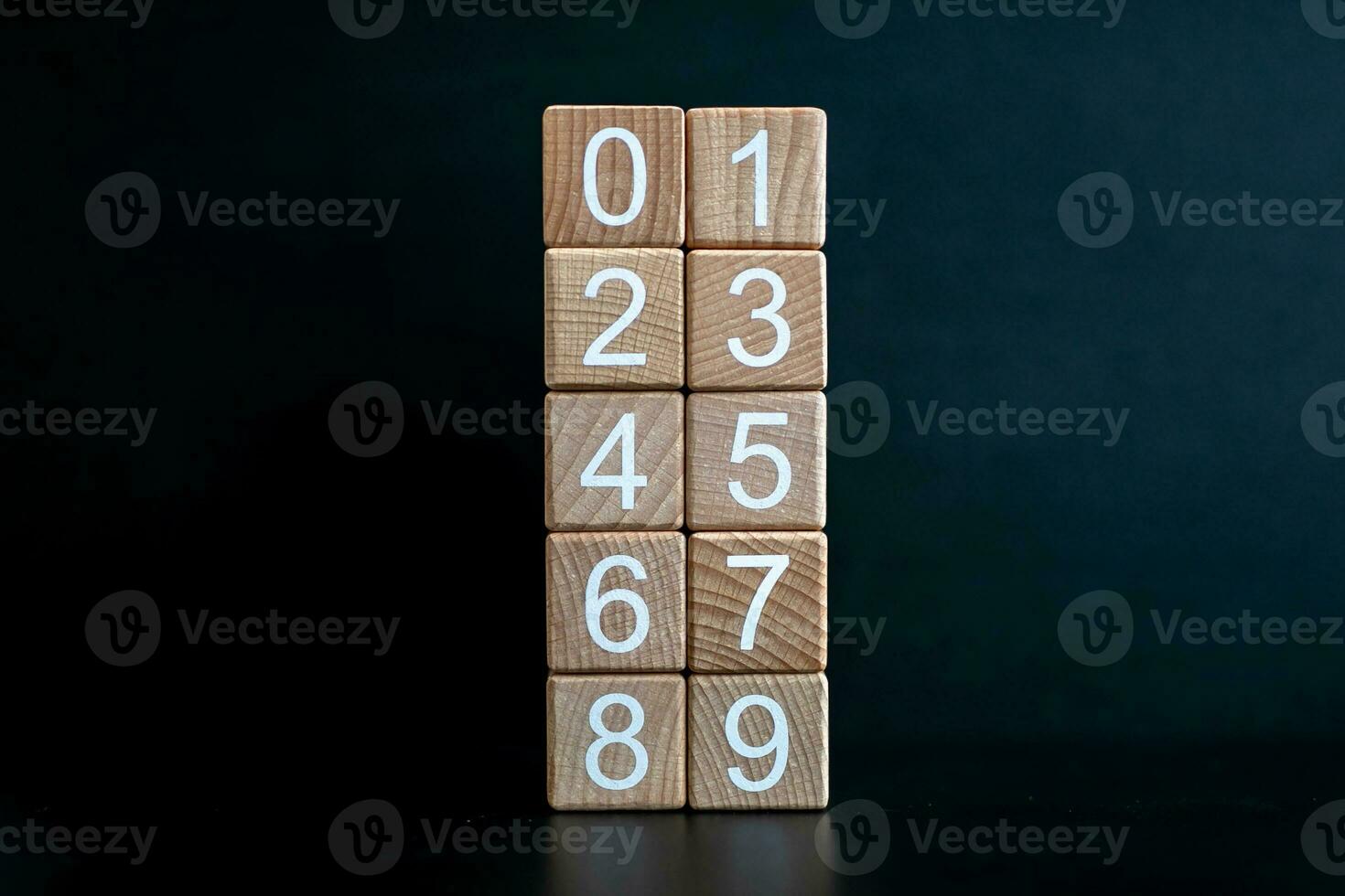 Several wooden blocks arranged from 0-9 vertically against a black background. photo