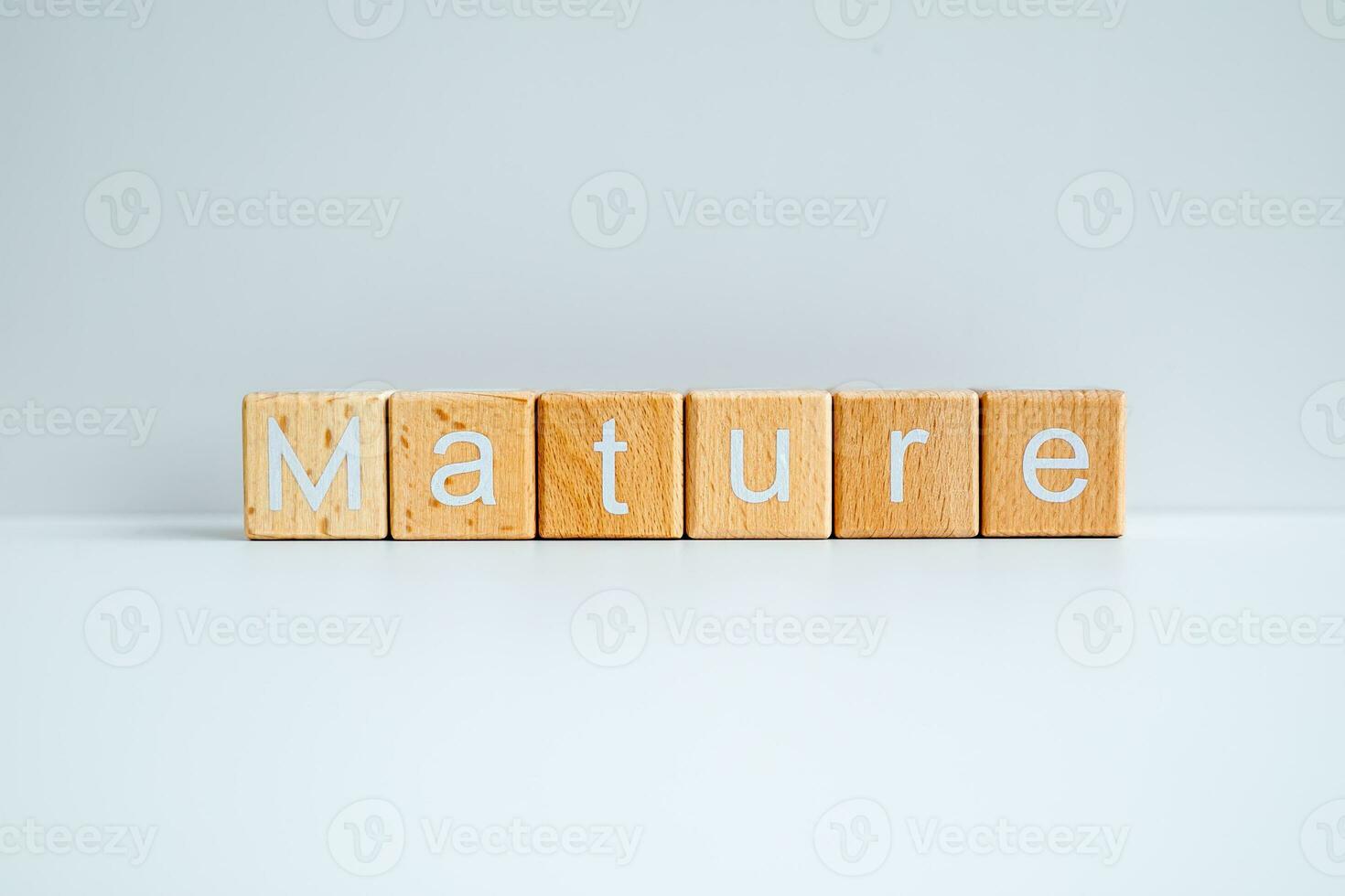 Wooden blocks form the text Mature against a white background. photo