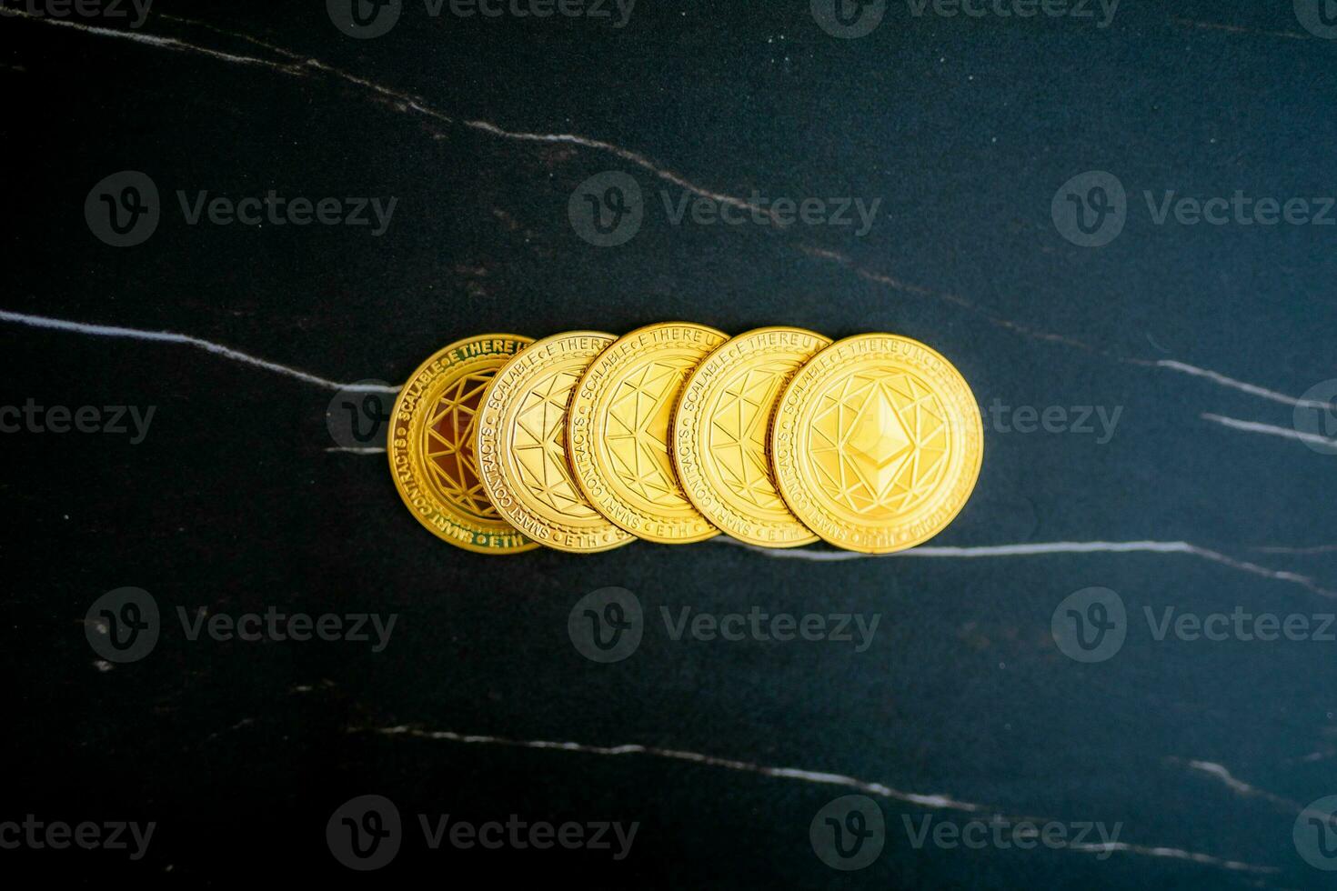 5 Ethereum coins ETH stacked on a black marble background. photo