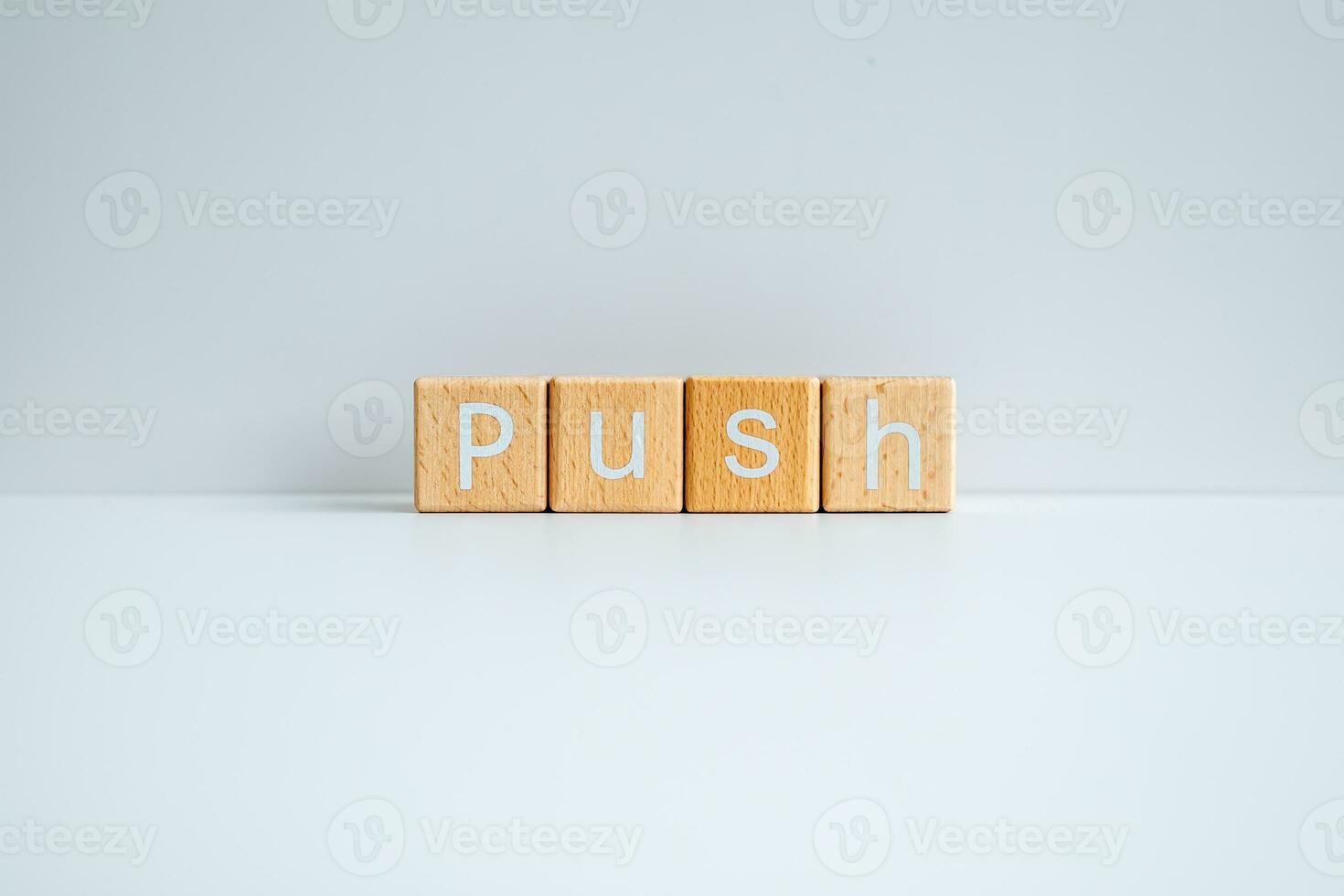 Wooden blocks form the text Push against a white background. photo