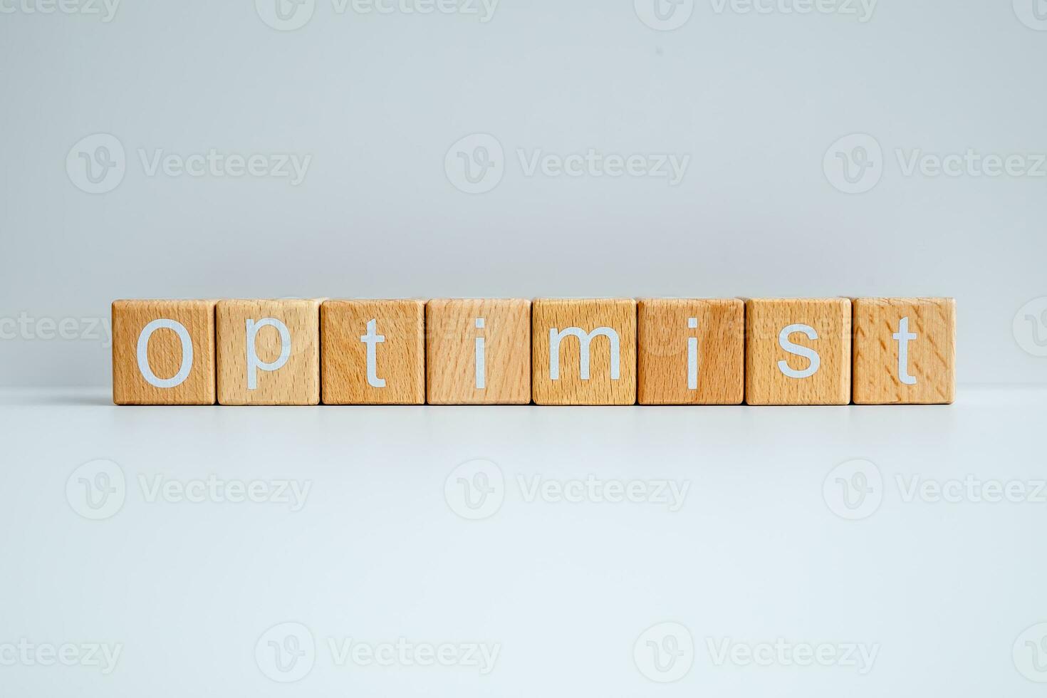 Wooden blocks form the text Optimist against a white background. photo