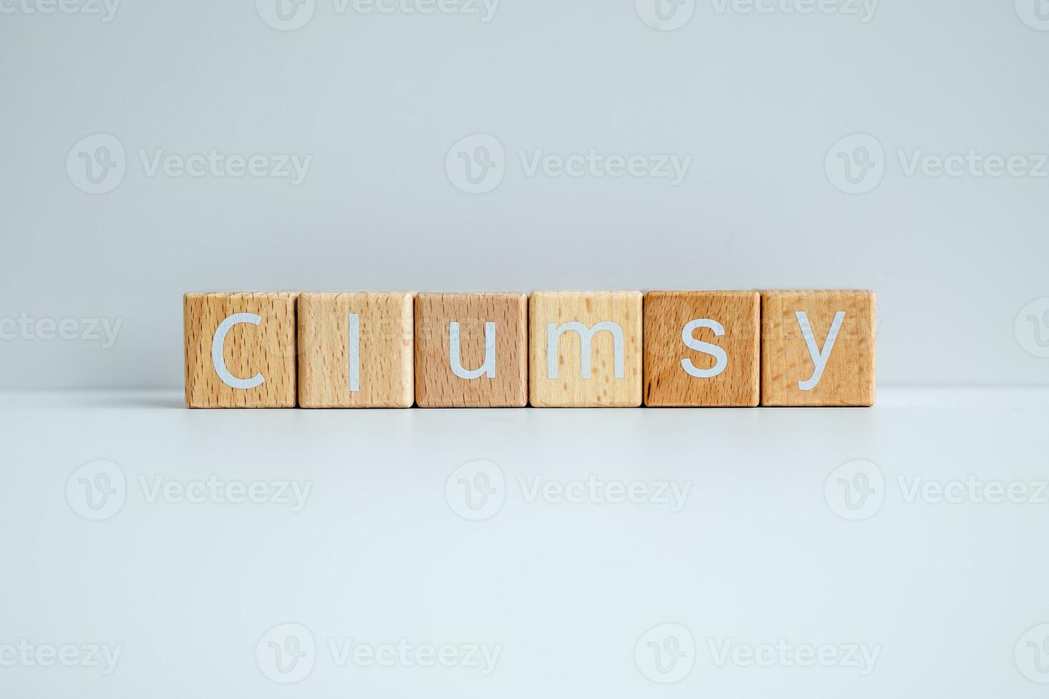 Wooden blocks form the text Clumsy against a white background. photo