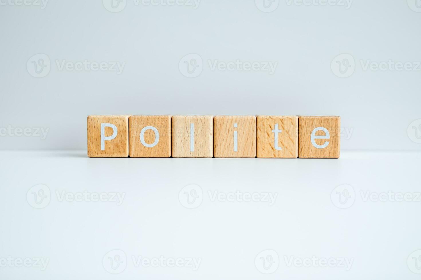 Wooden blocks form the text Polite against a white background. photo