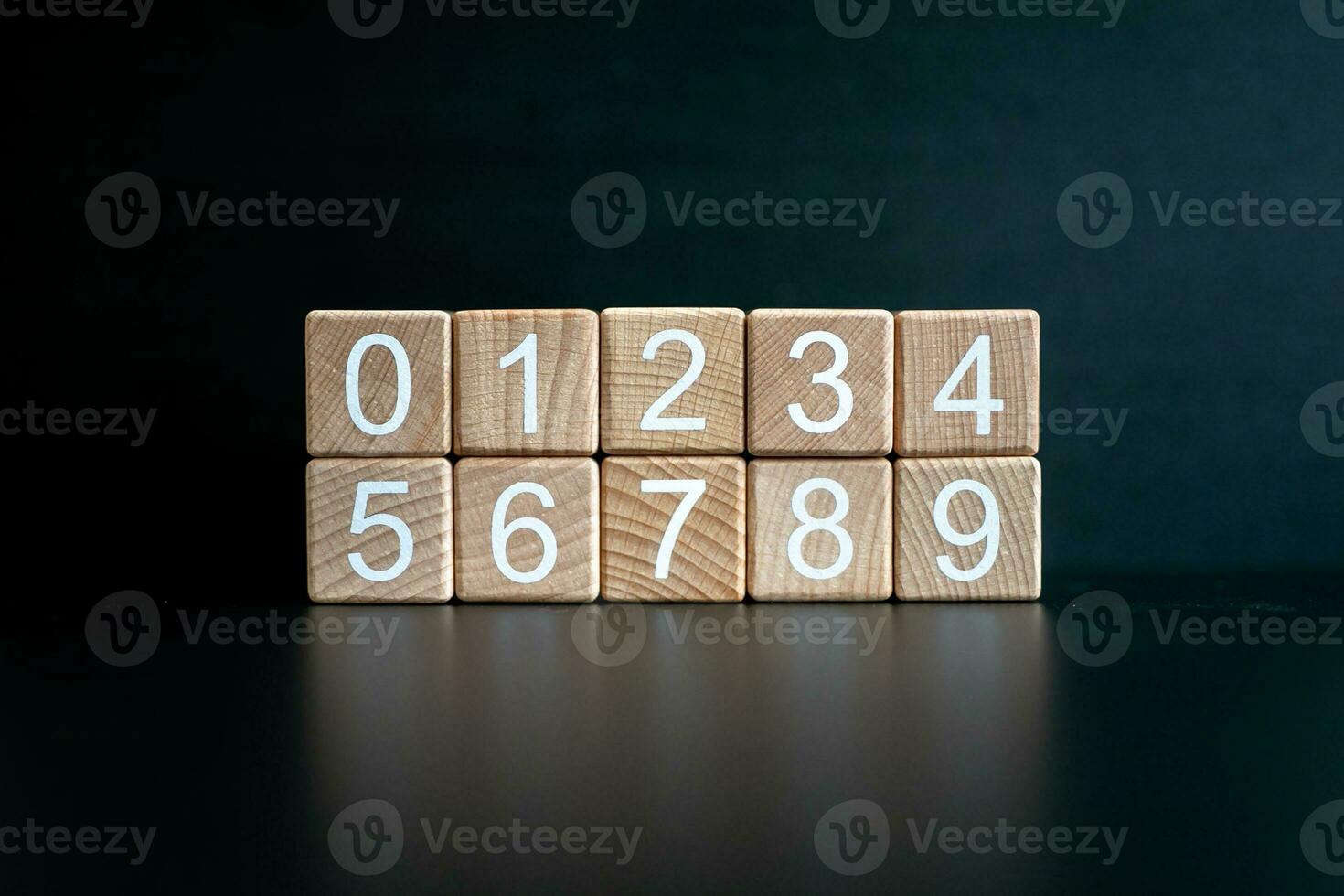 Several wooden blocks arranged from 0-9 horizontally against a black background. photo